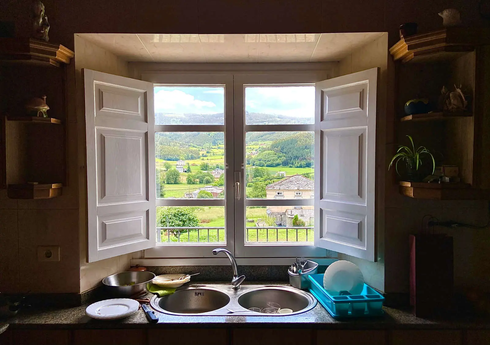 Clean kitchen with the window open onto the countryside and a tidy sink