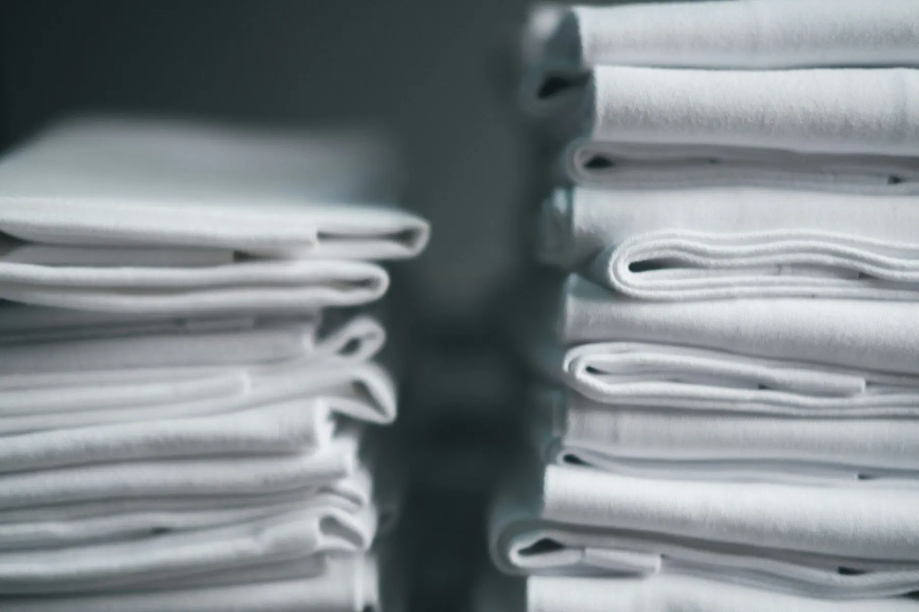 Stacks of folded white towels and sheets
