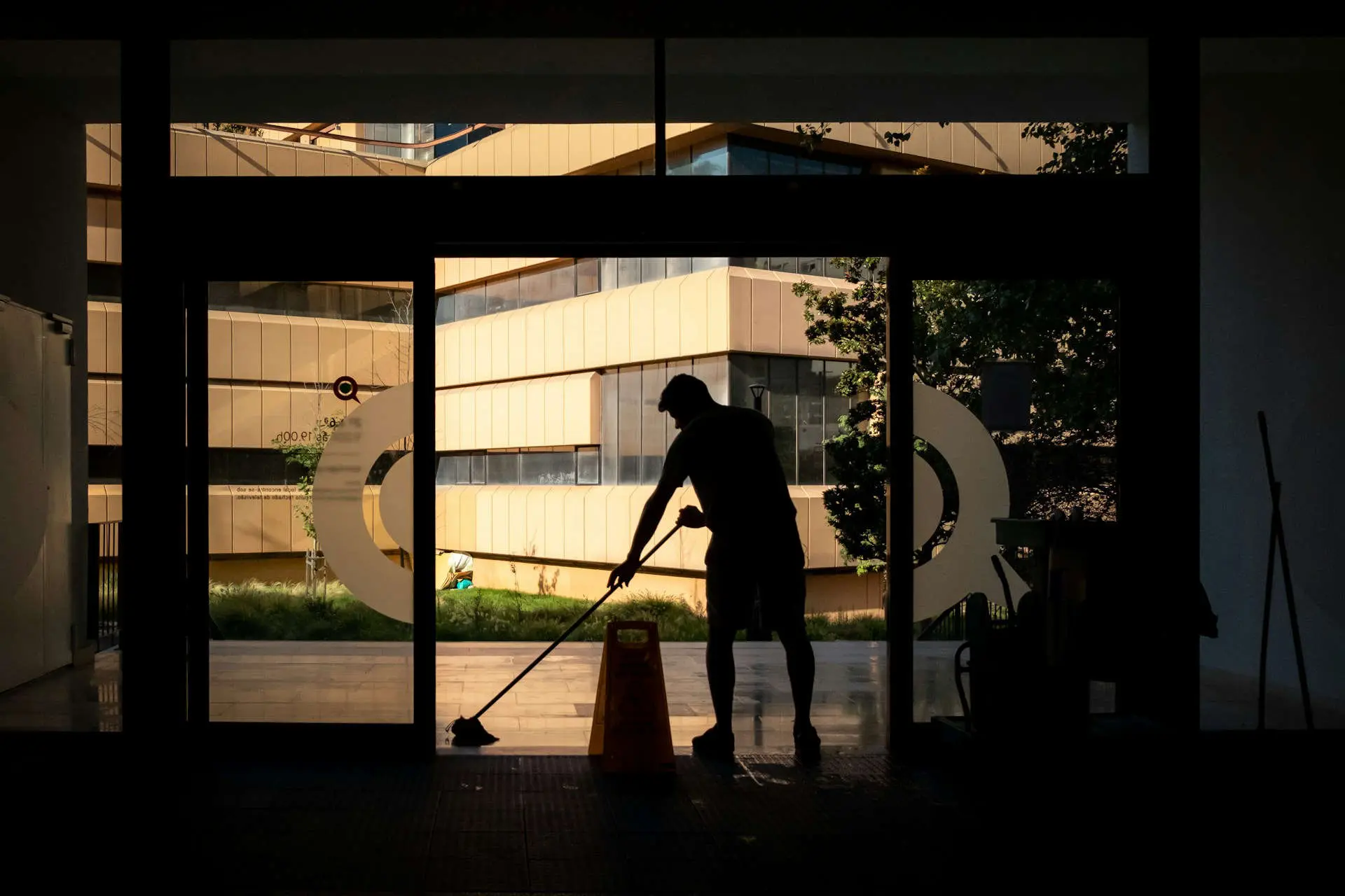 Worker mopping the entrance floor of a commercial unit
