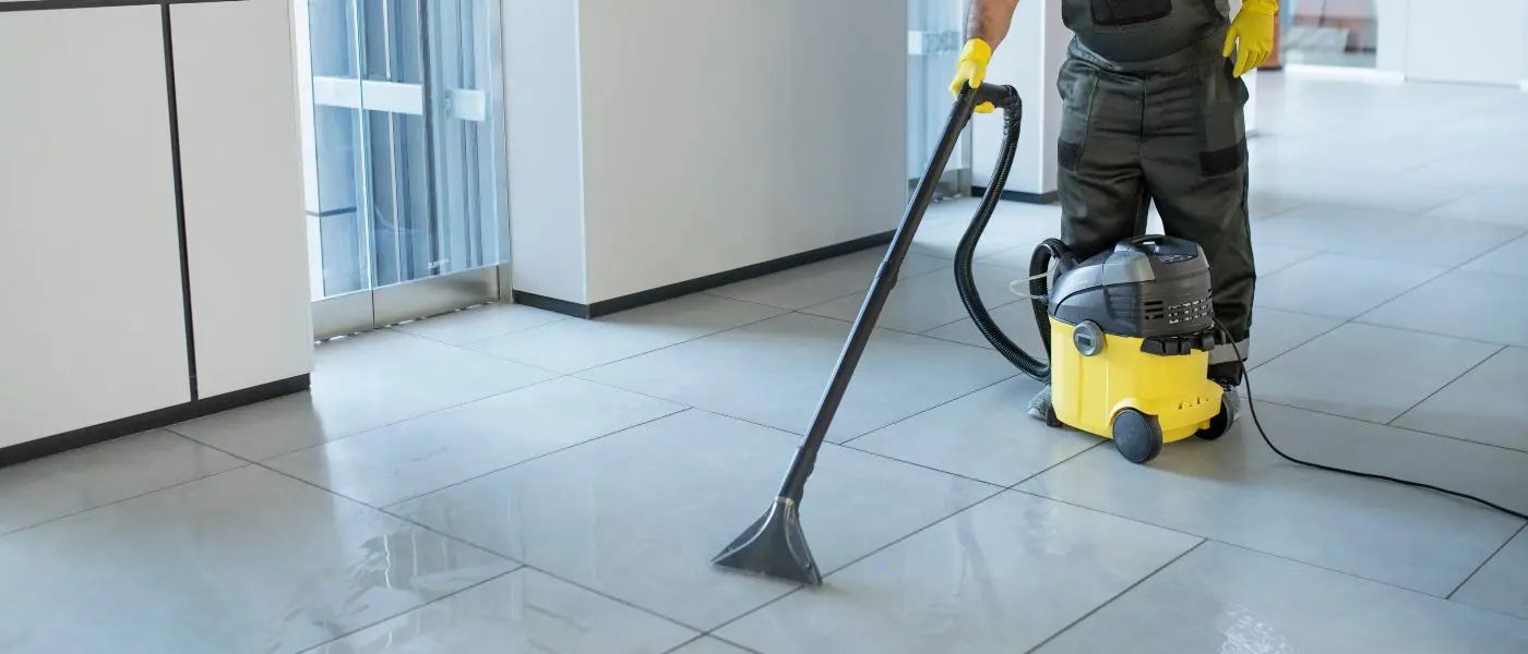 Worker vacuuming a landing floor with an industrial vacuum cleaner