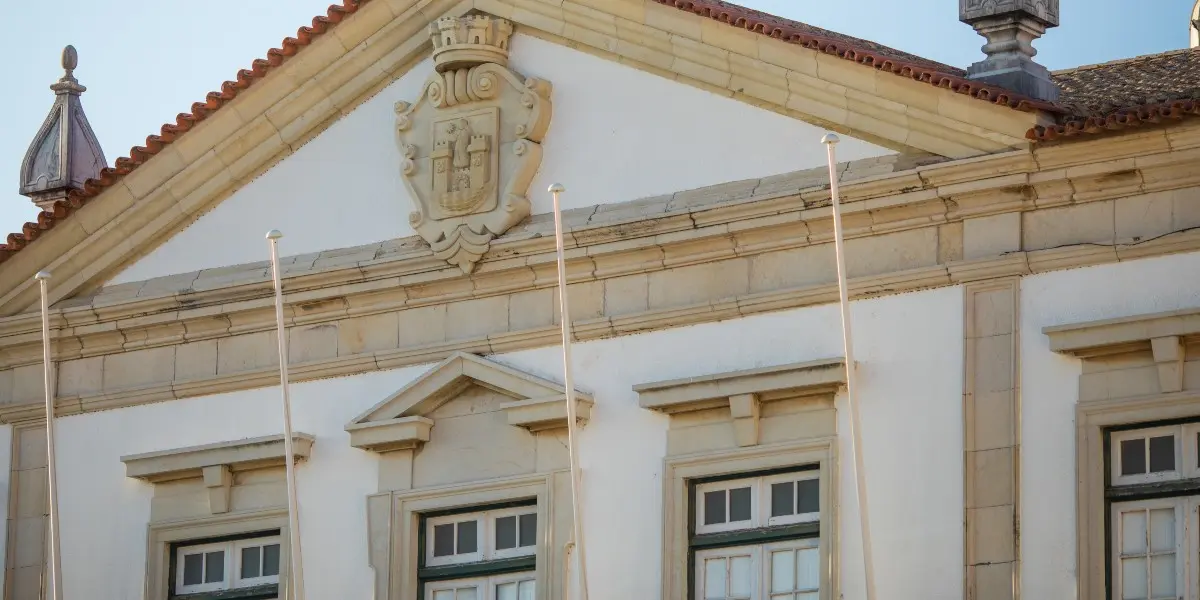 Front of a town hall building with a coat of arms