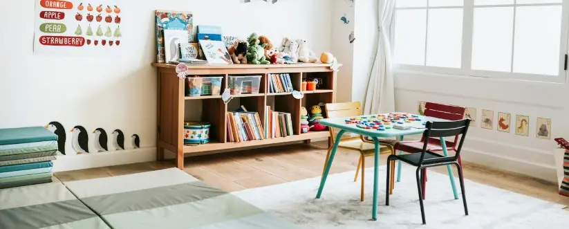 Nursery play corner with a bookcase, toys and a small table
